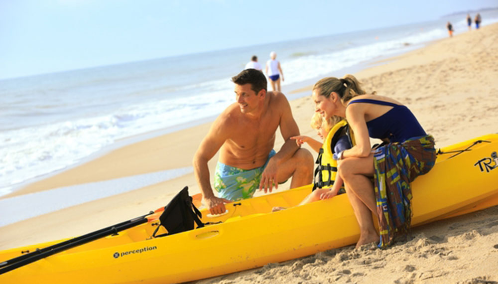 mom, husband and son preparing to kayak beachfront