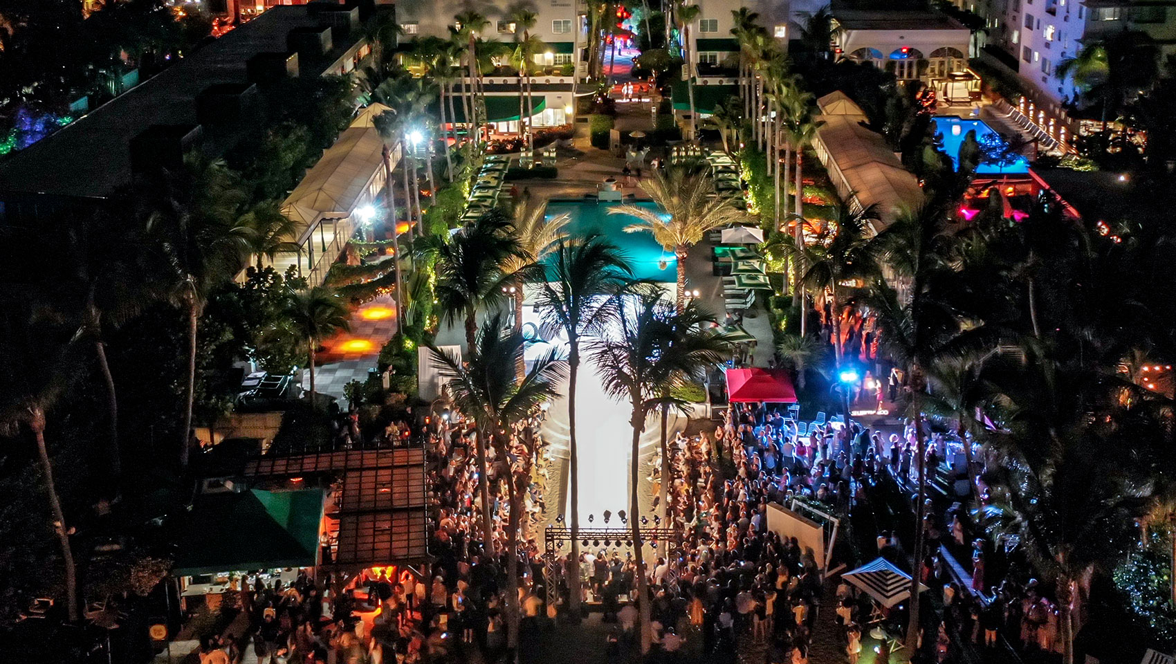 Nighttime aerial image of Kimpton Surfcomber during an Ocean Drive Swim Week runway show