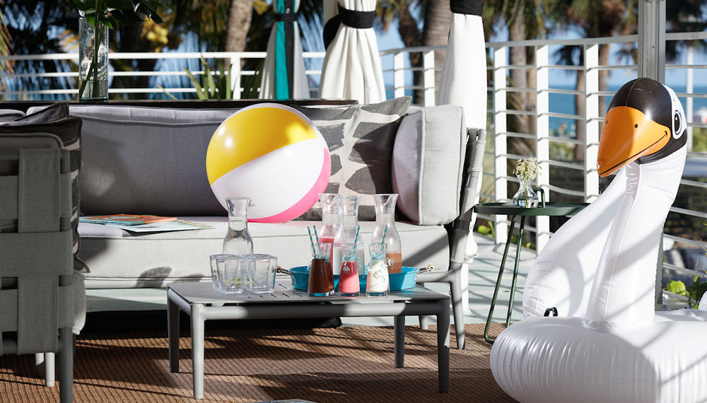 cabana with drinks, a beach ball and a swan floatie