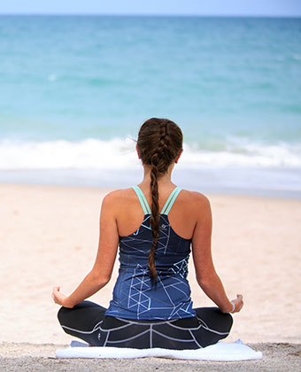 woman doing yoga on beach