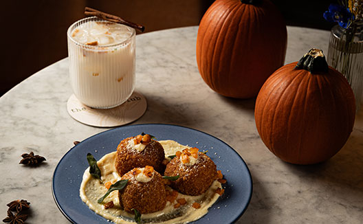 Table with fall themed drink, food, and pumpkins