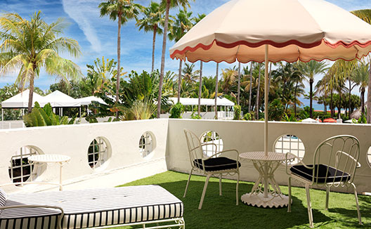 Oceanfront Terrace with seating and umbrella at Kimpton Surfcomber Hotel